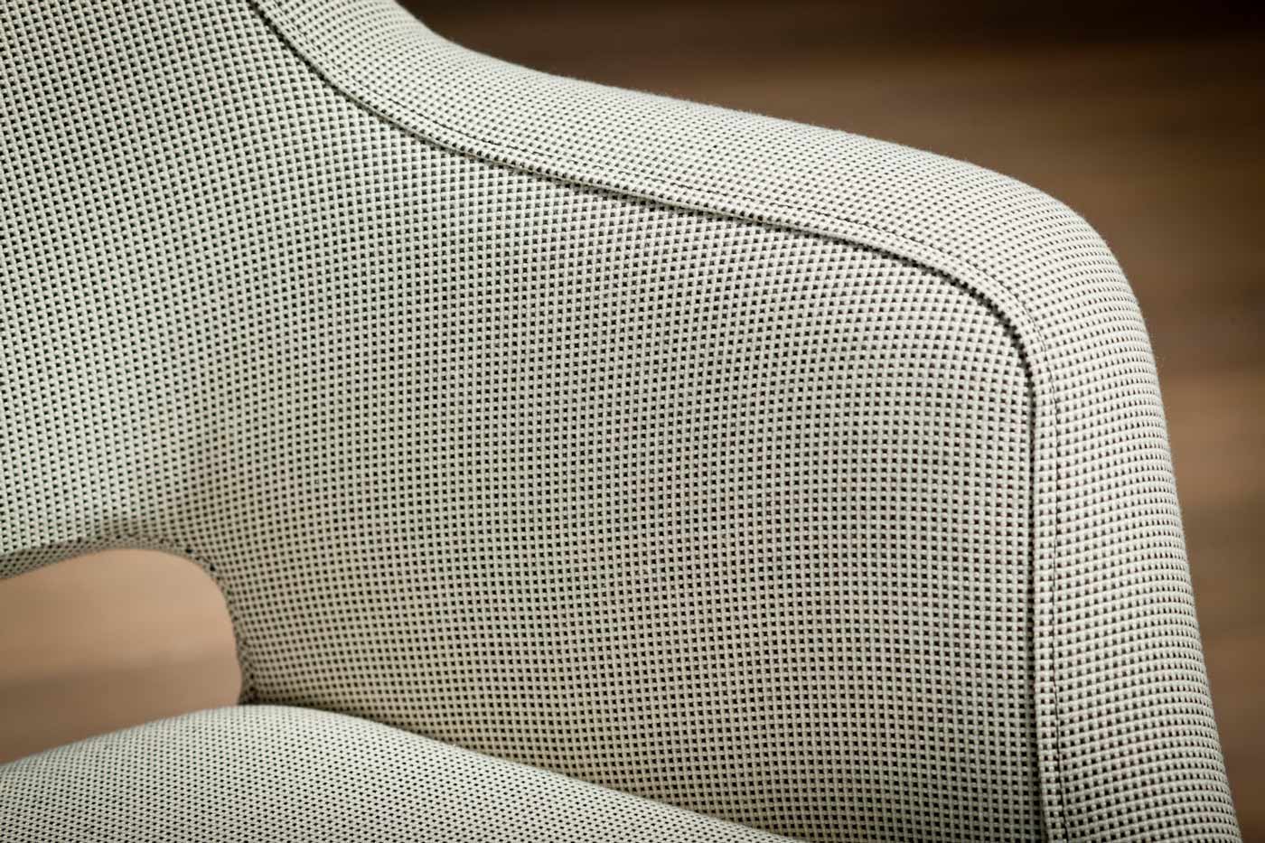 Detailaufnahme eines mit Stoff überzogenen Stuhls in beiger Farbe